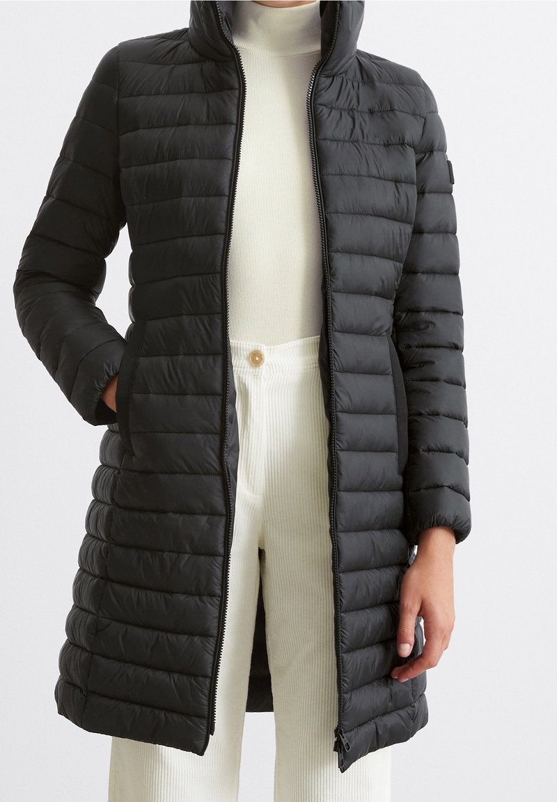 Polstret sort lang frakke med høj krave, der har et horisontalt quiltet design, lynlåslukning og to sidelommer. Glat tekstur.