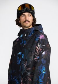 Veste noire avec un motif floral et galactique multicolore, dotée d'une fermeture éclair à l'avant, d'une capuche ajustable et d'accents de marque.