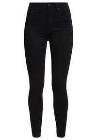Jeans skinny negros de denim, con cintura alta, textura suave y hardware mínimo, con un diseño clásico de cinco bolsillos.