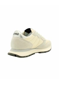 Beige Sportschuh mit Obermaterial aus Wildleder und Textil, grauen Akzenten, Gummisohle und markiertem Fersenelement. Verfügt über ein Schnürsystem und eine gepolsterte Zunge.