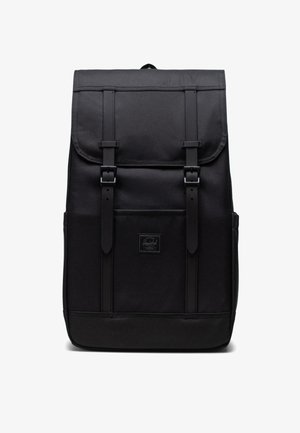 Čierny batoh s obdĺžnikovým tvarom, vyrobený z odolnej textílie. Obsahuje dva kožené popruhy, horný klip a prednú nášivku s logom.