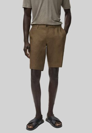 Brown tailored shorts with a flat front and side pockets, paired with a gray short-sleeve shirt and black slide sandals.