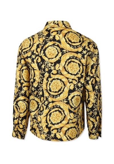 Maglietta nera a maniche lunghe con un intricato motivo floreale giallo e a scroll. Il tessuto sembra liscio, con un colletto classico e chiusura a bottoni.