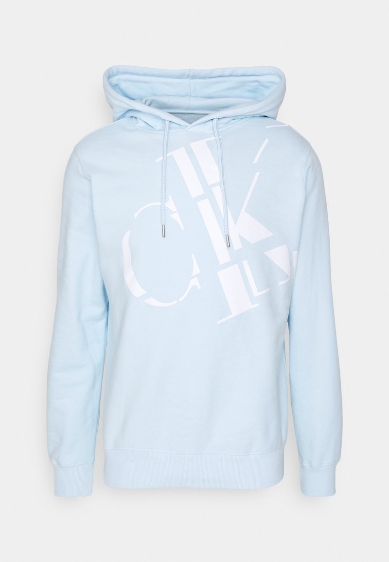 Sweat à capuche bleu clair avec un design de texte abstrait blanc sur le devant et des cordons suspendus à la capuche.