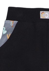 Schwarze Jogginghose mit einem gerippten Bund, ausgestattet mit grauen Seitentaschen, die mit bunten Mustern aus Formen und Buchstaben verziert sind.