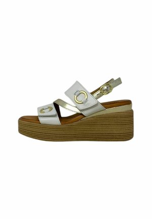 Sandali wedge bianchi e dorati con due cinghie incrociate e una fibbia, dotati di una suola piattaforma marrone con texture.