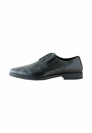 Zapato negro de piel con un acabado suave, diseño de cordones, puntera redondeada y suela plana de goma baja. Presenta detalles de costura mínimos.