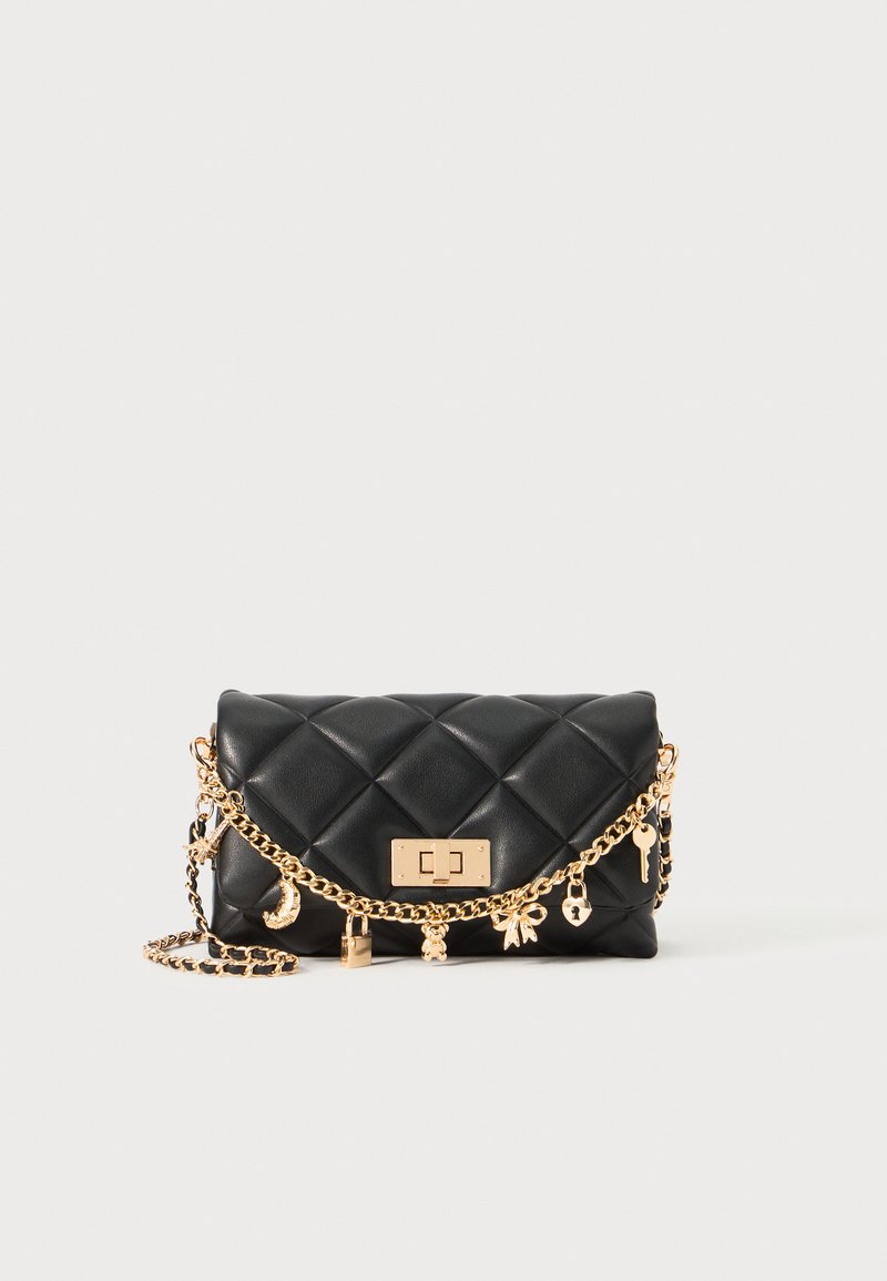 Bolso de cuero negro acolchado con cadena dorada y detalles de encanto, que presenta un cierre rectangular dorado y una silueta estructurada.