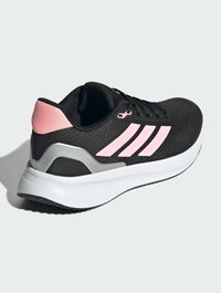 Baskets de course noires avec des rayures roses et une tige texturée. Présente un contrefort de talon gris et une semelle blanche texturée pour une adhérence optimale.