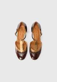 Scarpe in pelle marrone con una striscia d'accento dorato, dettaglio intrecciato e design con punta scoperta. Presentano una superficie texturizzata e un tacco basso.