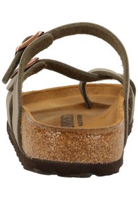 Sandales vert olive avec deux sangles ajustables, une semelle en liège et une semelle en caoutchouc. Matériau en daim texturé, accents en métal de couleur cuivrée.