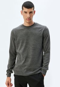 Grijze crewneck trui gemaakt van een zachte, textuurstof. Voorzien van lange mouwen en geribbelde manchetten en zoom voor een snug fit.