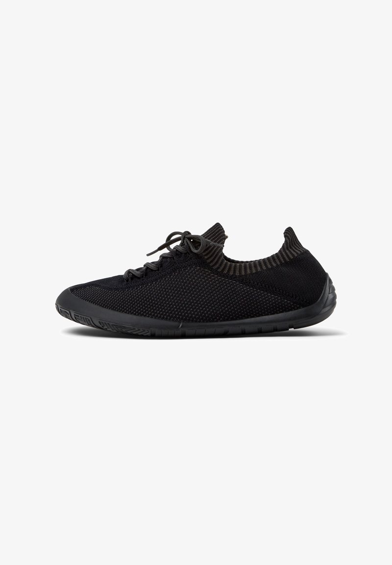 Schwarze Sportschuhe mit einem atmungsaktiven Mesh-Obermaterial, strukturierten Details, einer flexiblen Gummisohle und einem flachen Design.