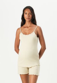 Set di top senza maniche e pantaloni corti beige chiaro, con pizzo decorativo, texture morbida e motivo a piccoli pois. L'orlo dei pantaloni corti presenta un bordo scallop.