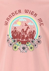 Unisex pink bomulds T-shirt med et rundt motiv af bjerge, blomster og teksten "Wander With Me" i jordnære farver.