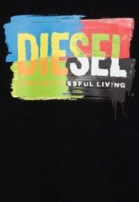 Tessuto nero con una grafica multicolore che presenta "DIESEL" in lettere bianche in grassetto e "PER UNA VITA DI SUCCESSO" in testo arancione più piccolo.