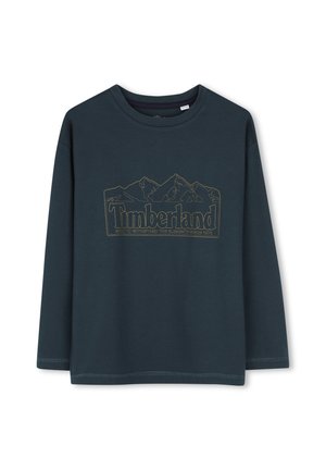 Chemise à manches longues vert foncé avec col rond et logo Timberland présentant le contour d'une montagne et texte au centre devant.