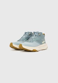 Ανοιχτό μπλε παπούτσια πεζοπορίας με πλέγμα και συνθετικό επάνω μέρος, επενδεδυμένο κολάρο και καφέ εξωτερική σόλα από καουτσούκ με υφή. Διαθέτει λογότυπο στην πλευρά.