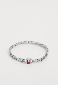 Bracelet en chaîne argentée avec des maillons entrelacés et un fermoir rectangulaire doté d'un accent rouge et bleu. Fini en métal lisse et poli.