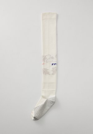 Ciorap lung, de culoare crem, cu un model floral subtil, având o secțiune pe partea piciorului în dungi gri și text albastru. Material neted cu un design în nervuri.