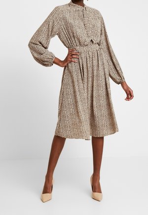 Vestido de manga corta hasta la rodilla en beige con un pequeño estampado oscuro. Cuenta con cintura fruncida y cuello abotonado.