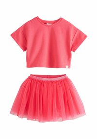 Camiseta rosa recortada con mangas cortas, combinada con una falda de tul rosa con una cinturilla elástica fruncida. Textura ligera y aireada.