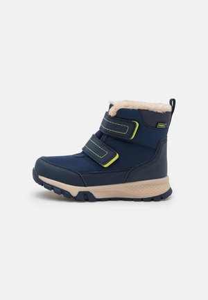 Botte d’hiver bleu marine avec semelle beige, deux sangles velcro réglables et doublure en polaire beige, conçue pour le temps froid.