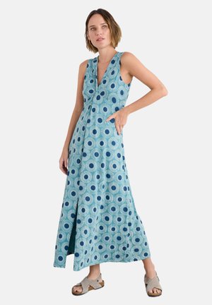 Maxi dress featuring a deep V-neck, sleeveless design, and a turquoise fabric adorned with sunburst and circular patterns in navy.