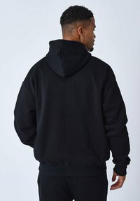 Schwarzer Kapuzenpullover mit lockerer Passform, ausgestattet mit einer gefütterten Kapuze, gerippten Bündchen und Saum. Weicher Stoff mit keinem sichtbaren Muster.