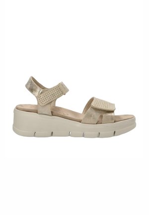 Sandalias de plataforma beige con una correa ajustable y acentos perforados. Material superior texturizado y plantilla acolchada para mayor comodidad.