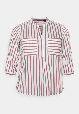 Biała bluzka w pionowe różowe paski, z rękawami 3/4, dwoma poziomymi paskowanymi kieszeniami na piersi oraz dekoltem w kształcie litery V.