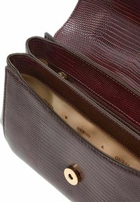 Bordowa torebka ze skóry o fakturze, z dwoma przegródkami, złotym zapięciem i beżowym wnętrzem z logo marki "Guess".