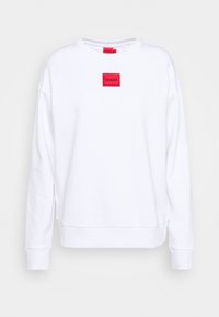 Sudadera blanca con cuello redondo, hombros caídos y puños acanalados, que presenta un parche de logo rectangular rojo en la parte frontal.