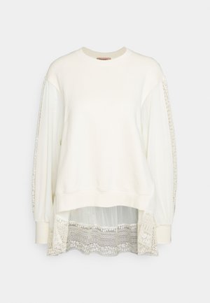 White sweatshirt with long, sheer fabric sleeves and a lace panel at the bottom hem. Features a ribbed neckline and casual fit.