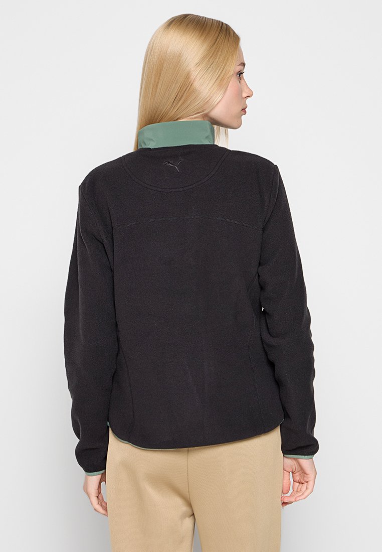 Zwarte fleece jas met een groene kraag, met een gestructureerd oppervlak en een klein logo op de rug. Eenvoudig ontwerp met een ontspannen pasvorm.