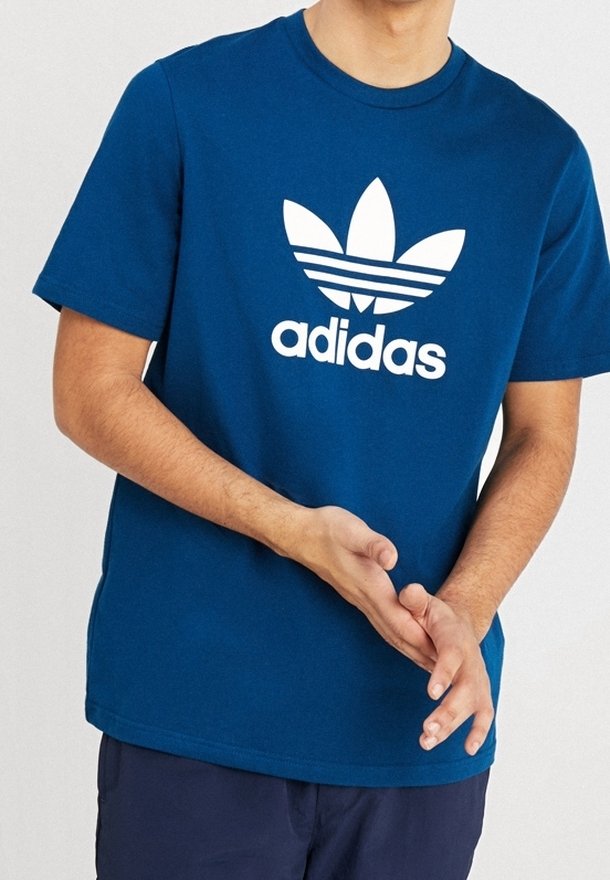Modrá bavlněná tričko s velkým bílým logem Adidas a třemi vodorovnými pruhy pod logem. Krátké rukávy, kulatý výstřih.