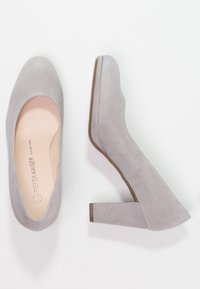 Chaussures à talons hauts en suede gris avec un bout rond, un talon carré et une texture lisse et mate avec un intérieur clair et neutre.
