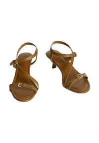 Sandalias de tacón marrones con un acabado de cuero suave, que presentan correas entrelazadas y un pequeño detalle de hebilla dorada en la correa del tobillo.