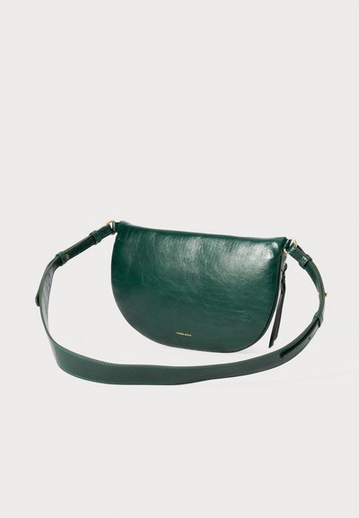 Borsa a tracolla verde in pelle con forma semilunare, texture liscia, tracolla regolabile e dettaglio di branding dorato sul davanti.