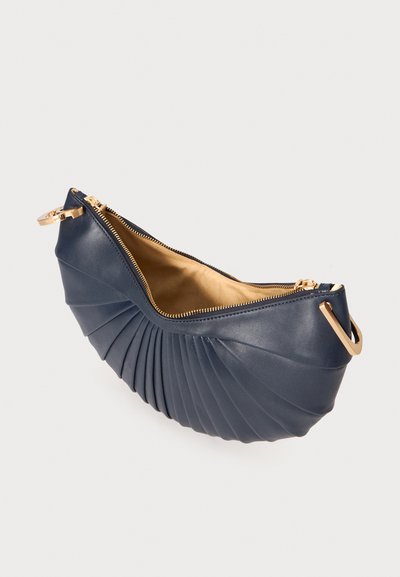Navy leather clutch bag with pleated design, golden zipper, and hardware accents. Interior features a smooth tan lining.