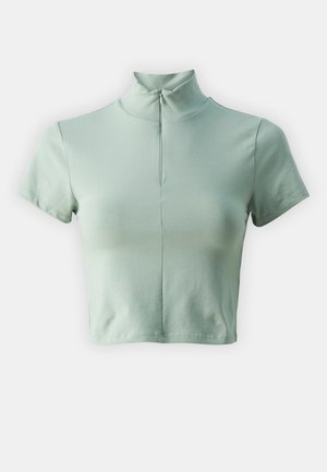 Top cropped verde chiaro a maniche corte con colletto alto e chiusura con zip sullo scollo. Tessuto morbido e liscio con design aderente.