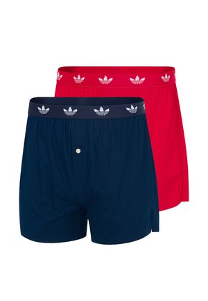 Deux caleçons Adidas, l'un bleu marine avec une braguette à boutons, et l'autre rouge, tous deux avec une ceinture élastique de marque.
