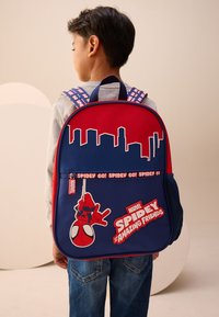 Red and blue backpack with Spider-Man graphic, skyline silhouette, and "Spidey Go!" text. Features padded straps and a mesh side pocket.