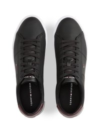 Schwarze Ledersneaker mit weißer Gummisohle, ausgestattet mit schwarzen Schnüren und einem burgunderfarbenen Akzent an der Ferse, Logo innen aufgedruckt.