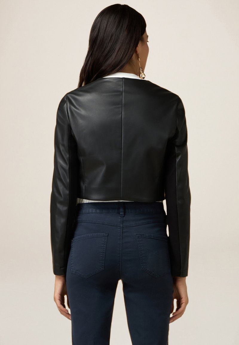 Oltre CORTA CON DETTAGLIO CATENE Giacca in similpelle nero