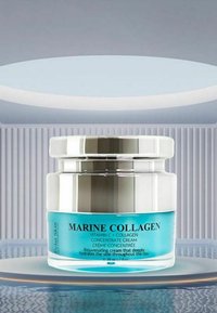 Szklany słoik z metalową srebrną pokrywką, zawierający jasnoniebieski krem. Etykieta z napisem "MARINE COLLAGEN" oraz dodatkowymi czarnymi napisami.