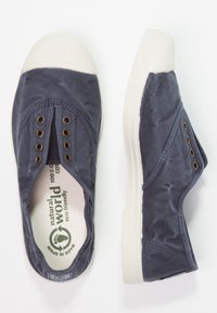 Modernega vojaško modrega platnenega čevlja brez vezalk z gumijastim belim zaščitnikom za prste, petimi kovinskimi obročki in okolju prijaznim označevanjem na notranji podplatu.