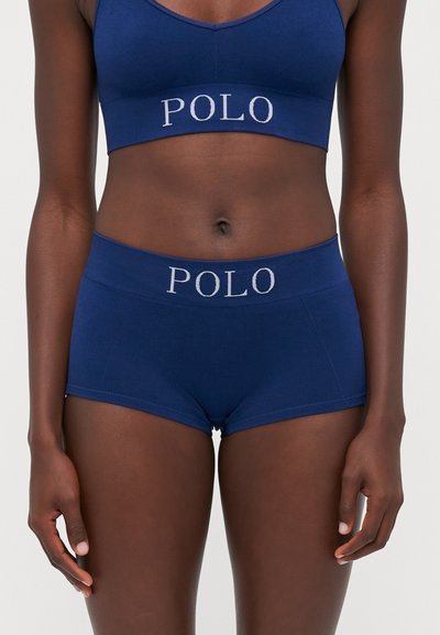 Tengerészsötétkék bordázott bralette és shorts szett, világosszürke "POLO" logóval a derékpánton. Puha, rugalmas anyagú, testre simító szabású.