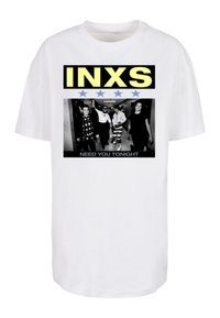 Fehér pamut póló, amelyen egy merész grafikai nyomat látható "INXS" felirattal sárgában, négy kék csillaggal, valamint egy fekete-fehér fényképpel, amelyen a "NEED YOU TONIGHT" felirat olvasható.