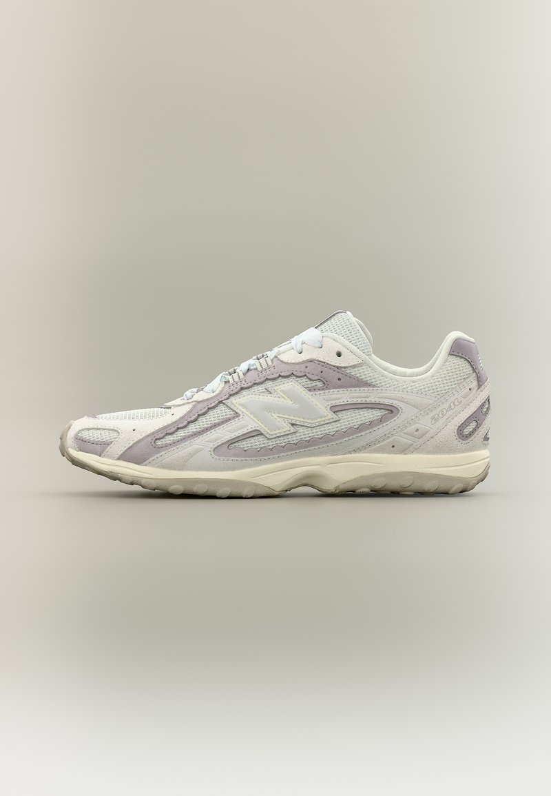 Sneaker New Balance bianca e grigio chiaro con tomaia in mesh e suede, suola ammortizzata e design con lacci, mostrata di profilo laterale.